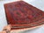 This antique hand-knotted Baluch rug features the classic Kalamdani "pen-case" design — four tall paneled devices filled...