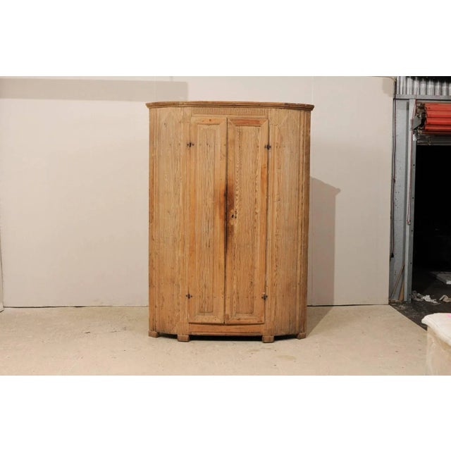 A Swedish 19th century period Gustavian corner cabinet. This Swedish corner cabinet features vertically reeded details on...