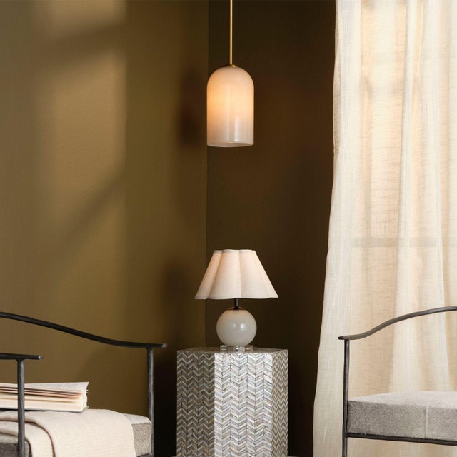 Suspended from a delicate yet solid antique brass rod, this pendant lamp features a hand-blown glass shade in soft taupe...