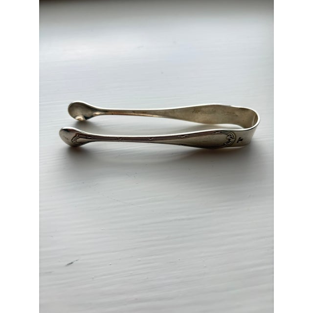 Sugar tongs by Christofle in the Rubans pattern, with a ribbon and bow motif on each arm, French Louis XVI–style...