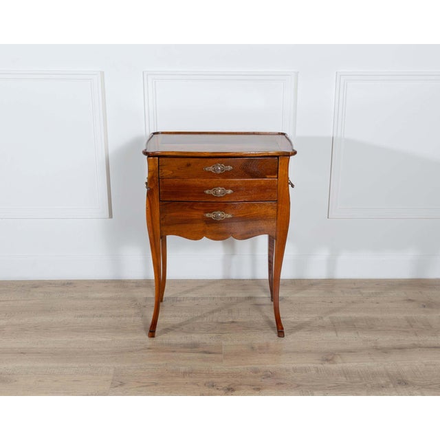 A refined late 19th-century cabinet or bedside table crafted in rich walnut, featuring a delicate writing desk function....