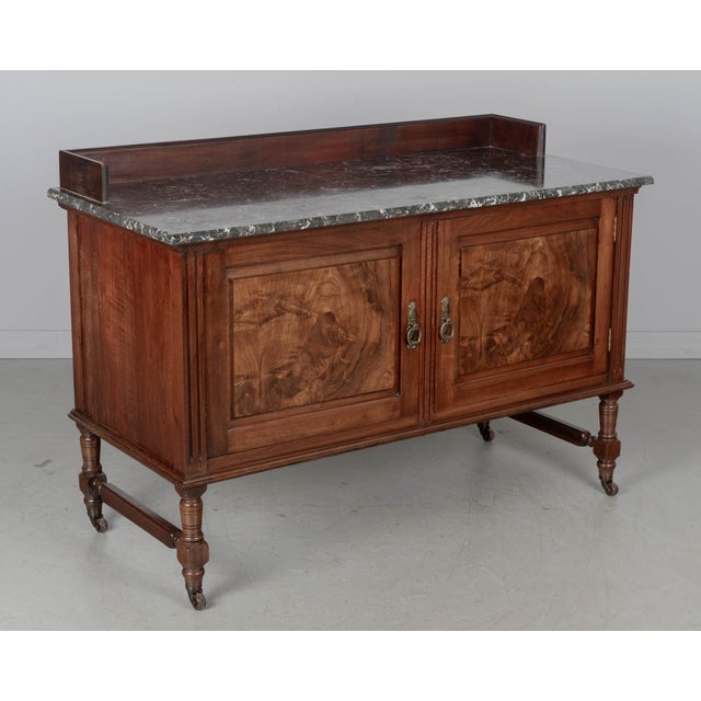 A 19th century English marble-topped washstand or sideboard by P. E. Gane. Made of solid and veneer of walnut with highly...