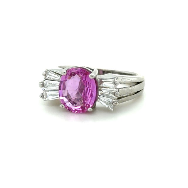 A beautiful GIA graded oval purplish-pink unheated sapphire takes center stage in this elegant ring, showcasing a rich,...