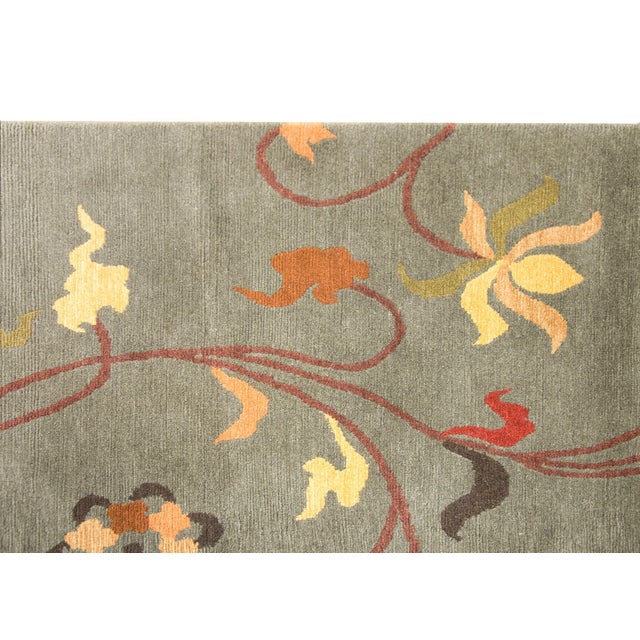 A chic late 20th century Tibetan hand-knotted rug with a gray background and an all-over scrolling vine and stylized...