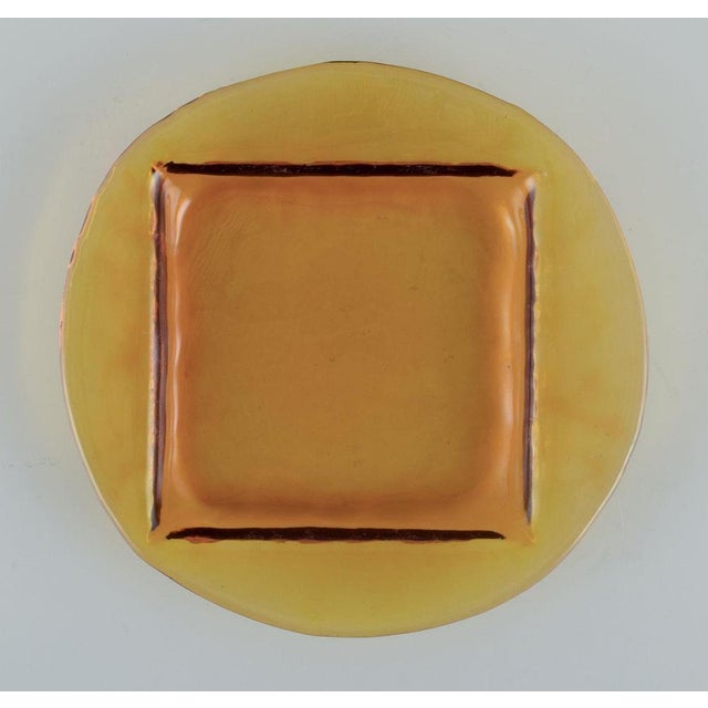 Scandinavian glass designer. A set of four plates in smoke-coloured art glass. Square indentation in the plate. Handmade...