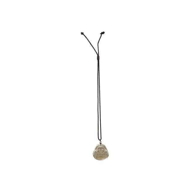 This elegant pendant is masterfully carved from clear, luminous crystal glass, capturing the joyful likeness of the...
