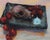 This oil on panel work presents a striking still life featuring a skull alongside vibrant red tomatoes arranged on a...