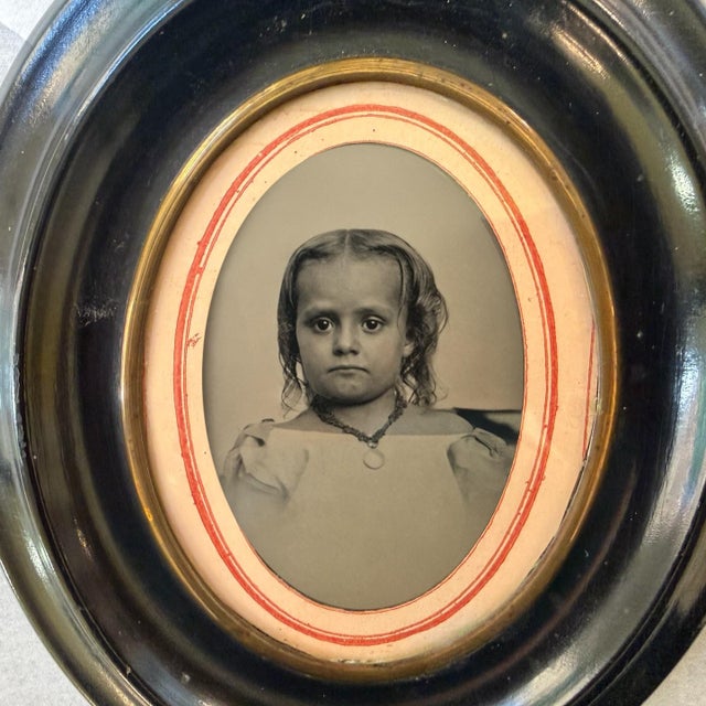 Antique 1860s Child Tintype Portrait in Ebonized Oval Frame with Convex Bubble Glass A charming and poignant piece of...