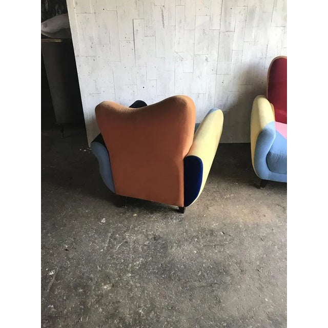 Mid -Century armchairs in multicoloured fabric with black painted legs.