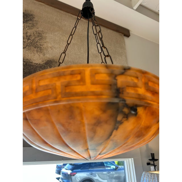 c. 1930s, translucent reddish alabaster stone bowl suspended by 3 chains to canopy, one hanging socket, 31.5"h x 16"w x 16"d