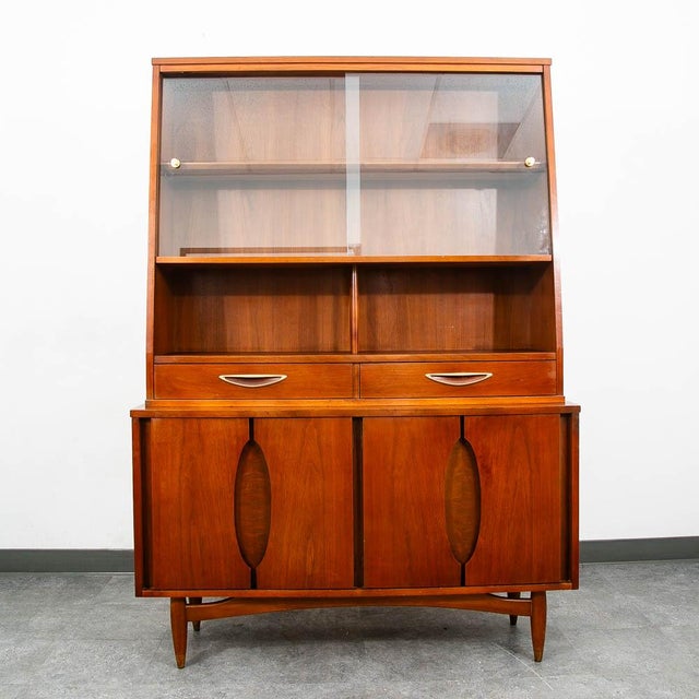 Mid Century Modern display hutch / china cabinet in walnut. This piece was created and sold by Garrison Furniture, Cir,...