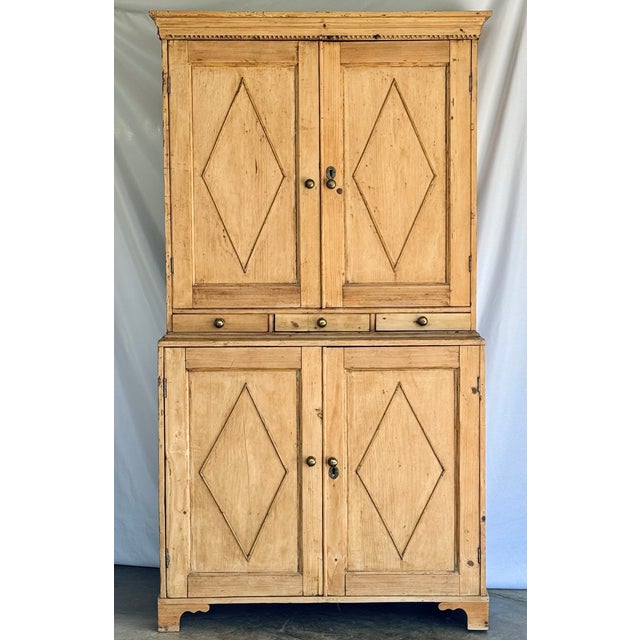 A large pine two piece step-back cabinet in pine. The upper half slightly recessed from the lower with the addition of...