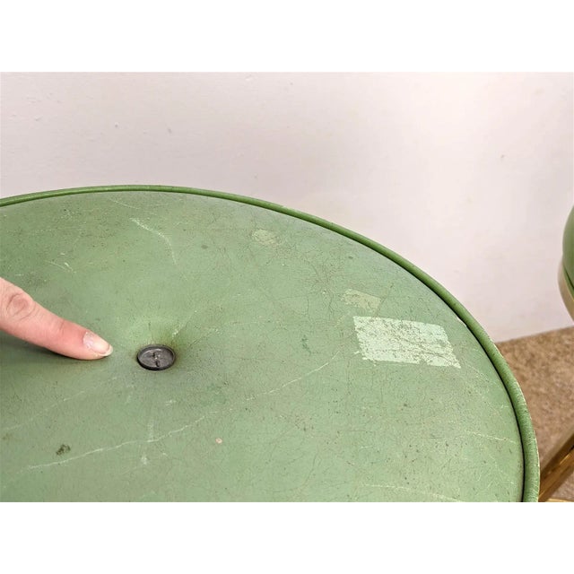 Two green and gold bar stools. Normal wear in metal, leather could use polish and missing button