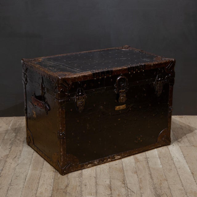 ABOUT Antique steamer trunk wrapped and trimmed in leather with original brass maker's label and studded with brass nail...