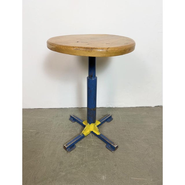 Vintage industrial stool. It features a blue iron leg and a solid wooden seat. The diameter of the seat is 35 cm. The...