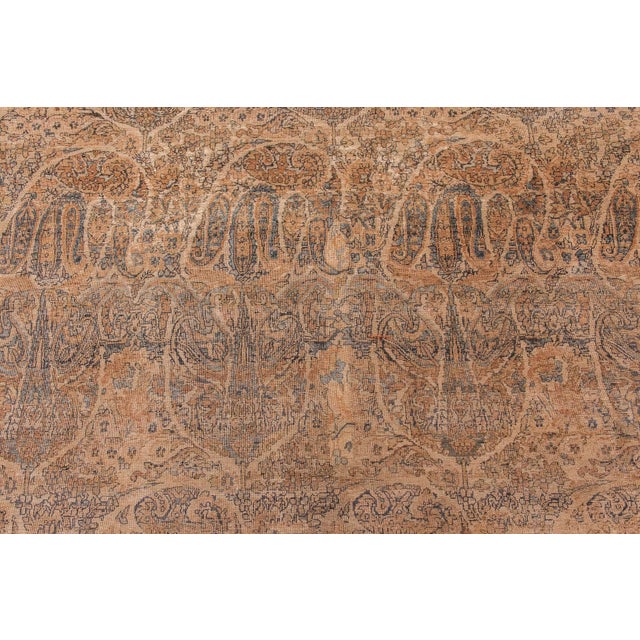 This majestic oversized antique Kirman rug, woven in Persia circa 1900, exemplifies the refined artistic tradition and...