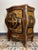 A stunning louis-style bombe commode, richly decorated with painted and inlaid details, featuring elegant brass pulls and...