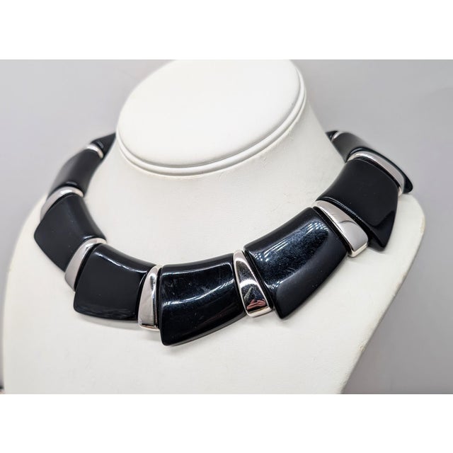 Rhodium plated black resin wedge shapes with rhodium plated spacers collar necklace with fold over clasp. Marked "Napier"...