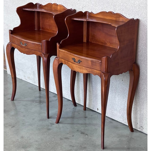A pretty pair of French one drawer nightstands with open shelf , circa 1910. Pair of French Louis XV style walnut bedside...