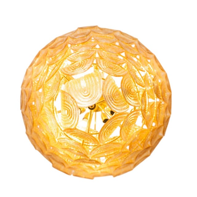 Italian Mid-Century Art Deco ceiling lamp in gilded Murano glass. The lamp features a structure of gilded brass rings,...