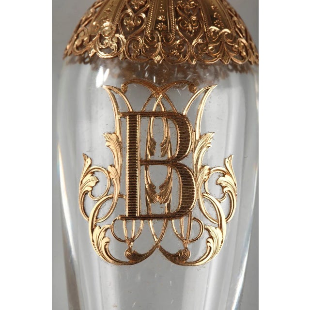 Eardrop-shaped crystal flask in pierced gold mount, intricately sculpted with hearts, palmettes, and scrollwork. The...