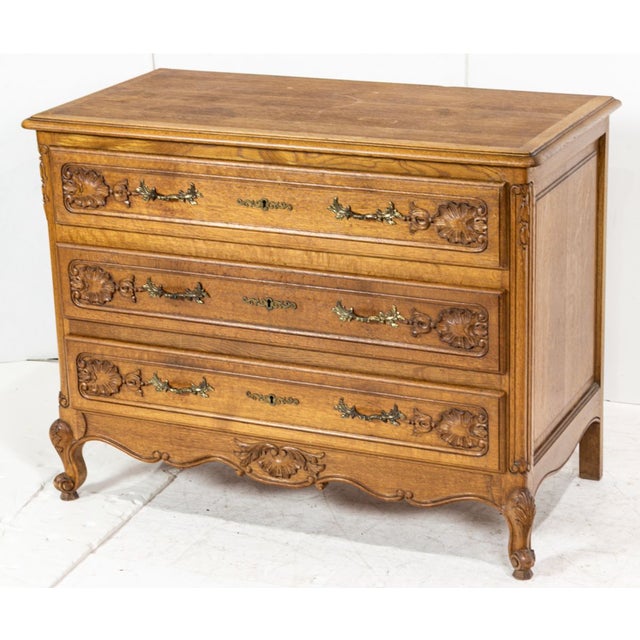 A charming French Provincial / Louis XV–style three-drawer chest, featuring a beautifully sculpted serpentine front,...