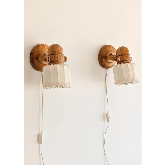 A charming pair of swedish wall lamps in solid pine, produced by markslöjd, showcasing the warmth and craftsmanship of...