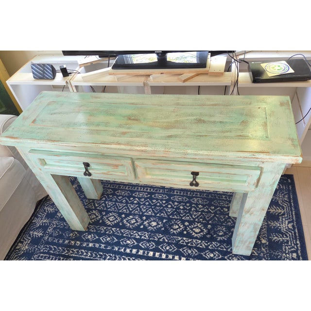 Beautiful rustic console table from Mexico. Has a unique distressed light green-blue-aquamarine finish, light wood tones,...