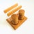 A vintage wood salt and pepper shaker and napkin holder set. 2 wood salt and pepper shakers sit neatly in circular grooves...