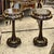 A sophisticated matching pair of French Neoclassical side tables, featuring rich dark wood finishes, glass-inset tops, and...