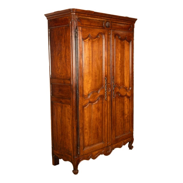 A good antique late 18th century carved French Provincial cherry wood armoire, circa 1780. The armoire having a ogee...
