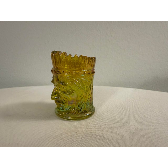 A striking vintage amber carnival glass figural holder featuring the classic North Wind-style face motif with a crown-like...