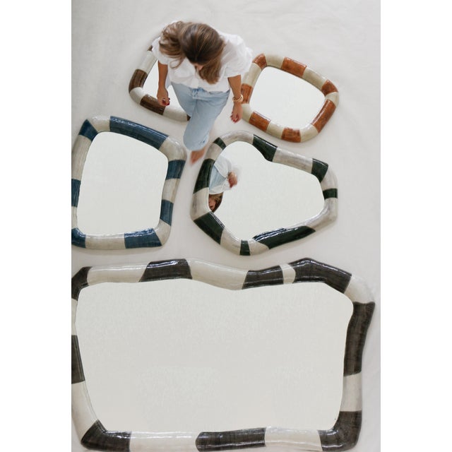 The ECHOE Mirror in terracotta and natural is a hand-sculpted, hand-cast and hand-painted collectible design piece in...