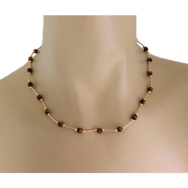This lovely necklace is crafted from 14k yellow gold featuring 5mm tiger's eye beads which has small gold beads and a long...