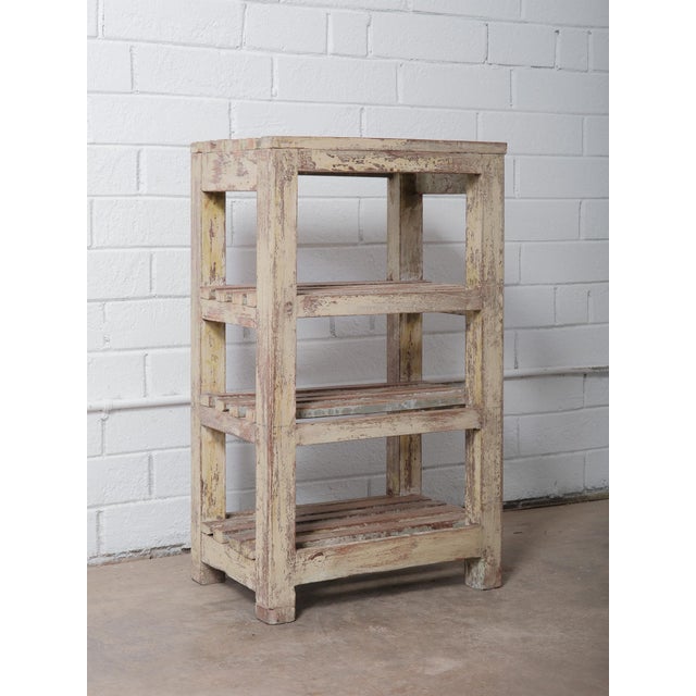 This antique Indian wooden shelf showcases beautifully aged character with its original, heavily distressed paint in soft...