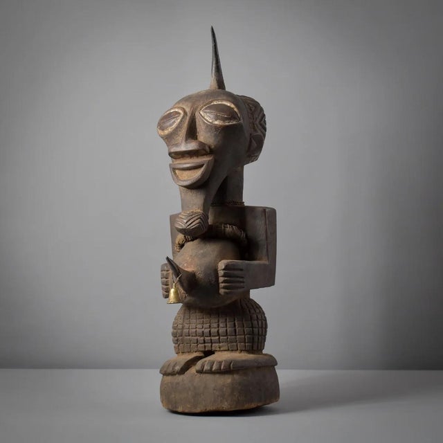 This intricately carved Songye standing figure exemplifies the distinctive artistic style of the Songye people,...