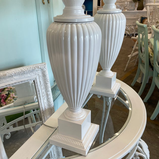 Pair of vintage brass fluted urn style lamps on a pedestal base. These lamps are simply classic and will never go out of...