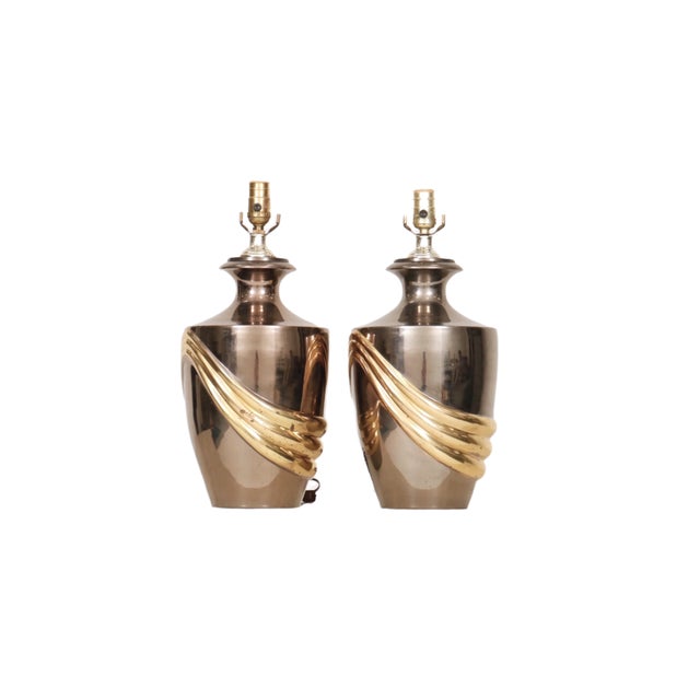 A pair of Art Deco style urn shaped table lamps made of chrome and brass. Brass sockets are supported on beveled necks...