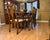 Elegant cherry dining table with six coordinating chairs, two extension leaves, and custom protective table pads. The set...