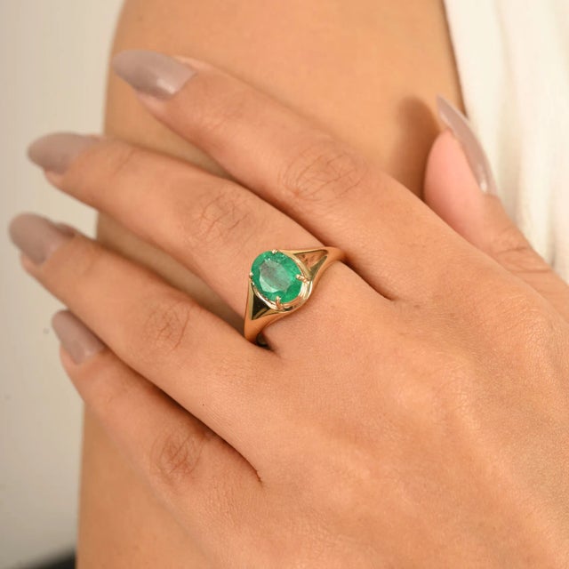 Elevate your jewelry collection with this timeless 14k gold emerald solitaire ring. Featuring a vivid oval-cut natural...