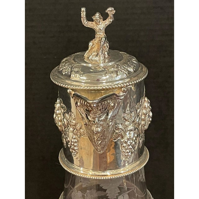 A Pair of English Sliver Plated and Engraved Glass Claret Jugs England, 20th Century A stunning pair of monumental English...