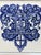 A classic Dutch Delft-style hand painted blue and white porcelain tile featuring an intricately rendered heraldic coat of...