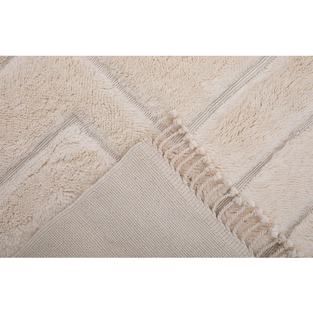 Elegant hand-knotted wool rug combines a Warm Ivory base with subtle geometric lines in a stepped pattern. The...