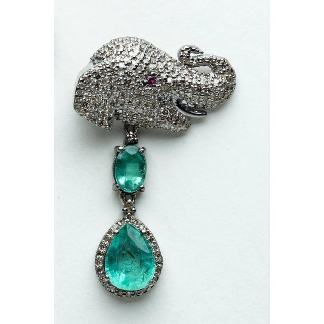 Pair of unusual elephant motif dangle earrings featuring pave`-set, round brilliant cut diamonds and ruby eyes on the...