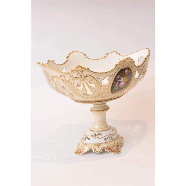 A stunning piece of Old Paris porcelain that features two sides of beautiful hand-painted floral panels, hand-cut work and...