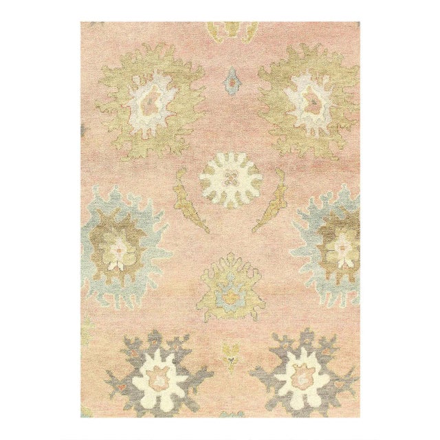 This Oushak Hand-Knotted Wool Pink/rose Area Rug celebrated for its understated elegance, is greatly influenced by...