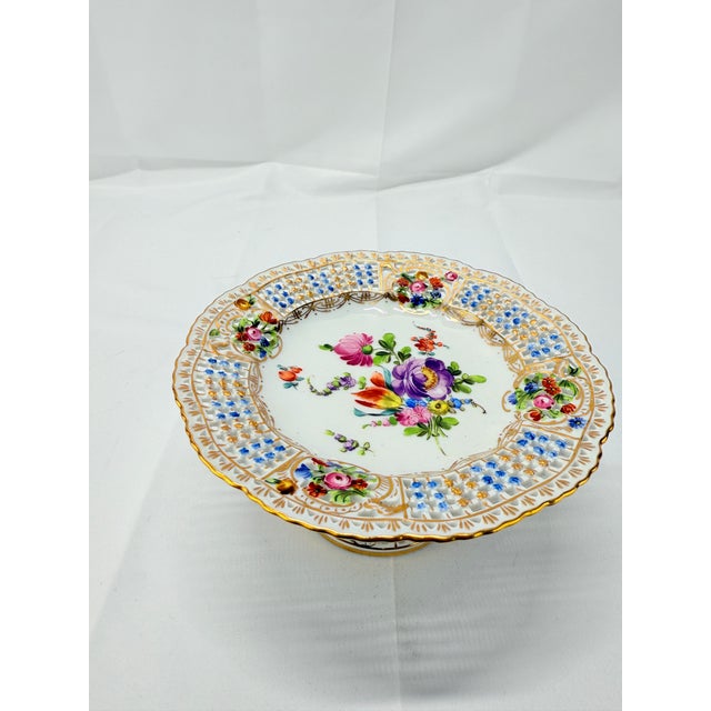 This early 20th-century Dresden floral encrusted and pierced porcelain compote retains the timeless elegance and...
