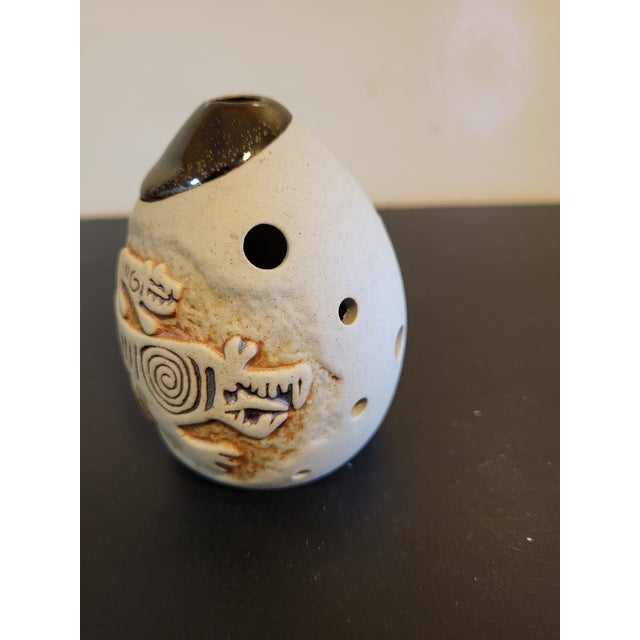 Ceramic sculpture, Asian origin, with a tan to terracotta coloration around some features. Can be used as a flute but...