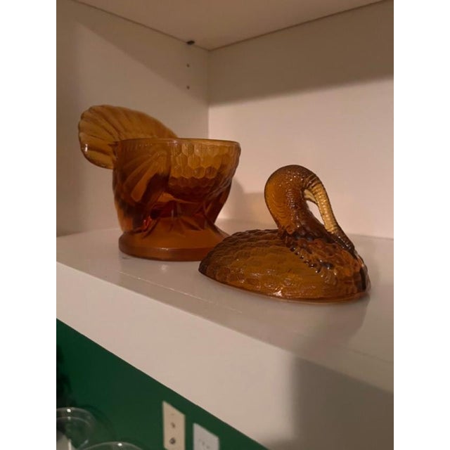This is a vintage pressed amber glass lidded dish shaped like a turkey, frequently attributed to the LE Smith Glass...