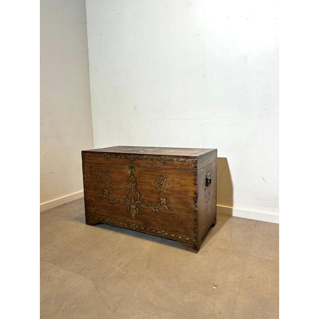This remarkable wooden storage chest features intricate brass inlay work across the front, top, and corners, forming...